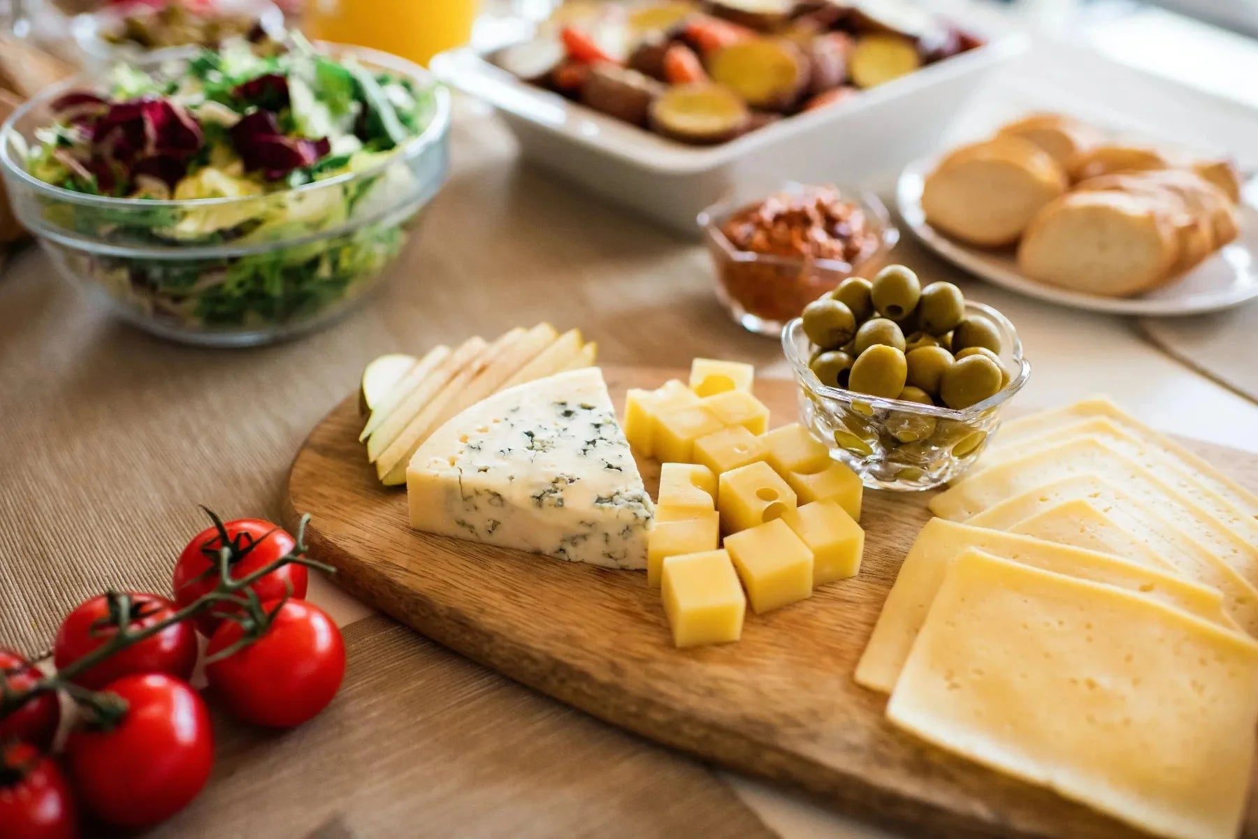 Various types of cheeses on a wooden board.