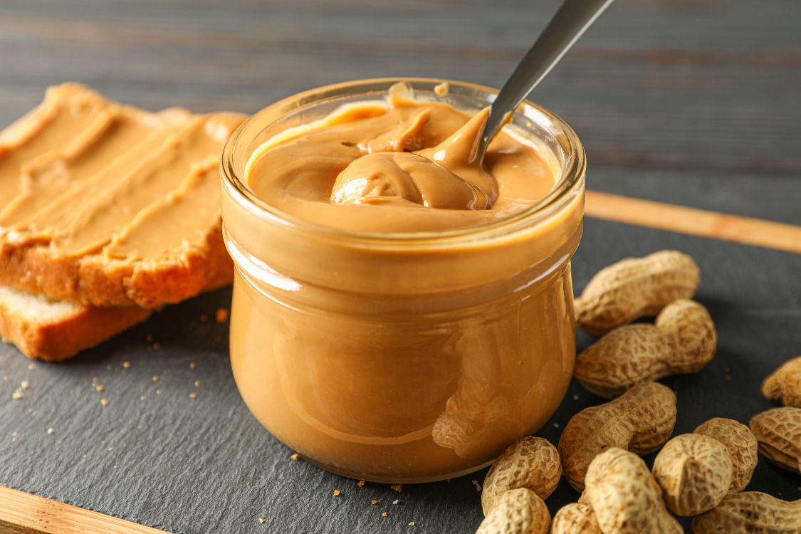 Creamy peanut butter on whole-grain toast, representing a safe, moderate serving size for a gout-friendly diet.