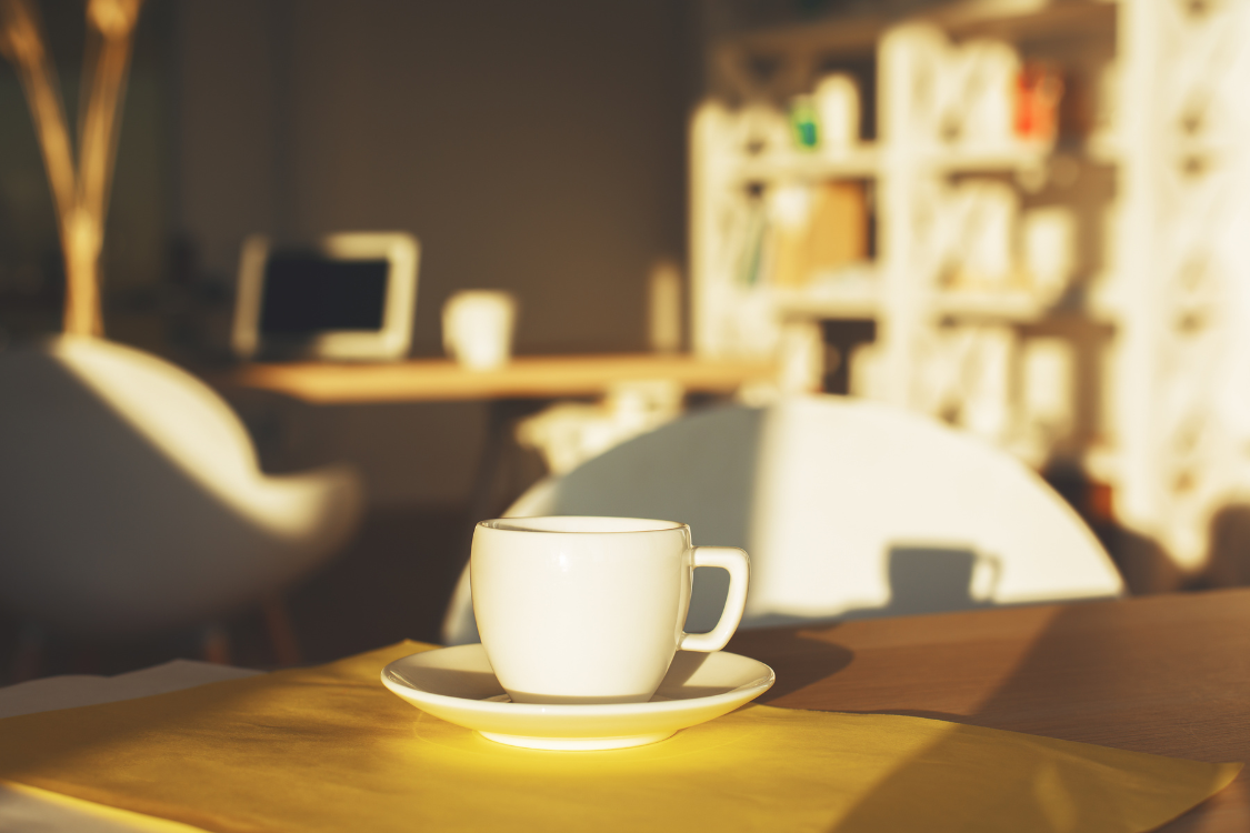 A cup of hot morning drink for uric acid placed on a sunlit table.
