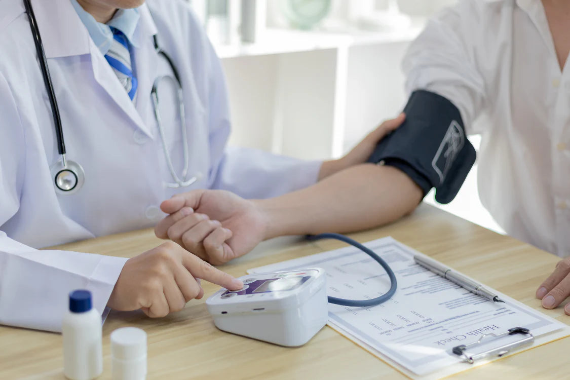 Arm with digital blood pressure monitor showing high blood pressure linked to kidney damage