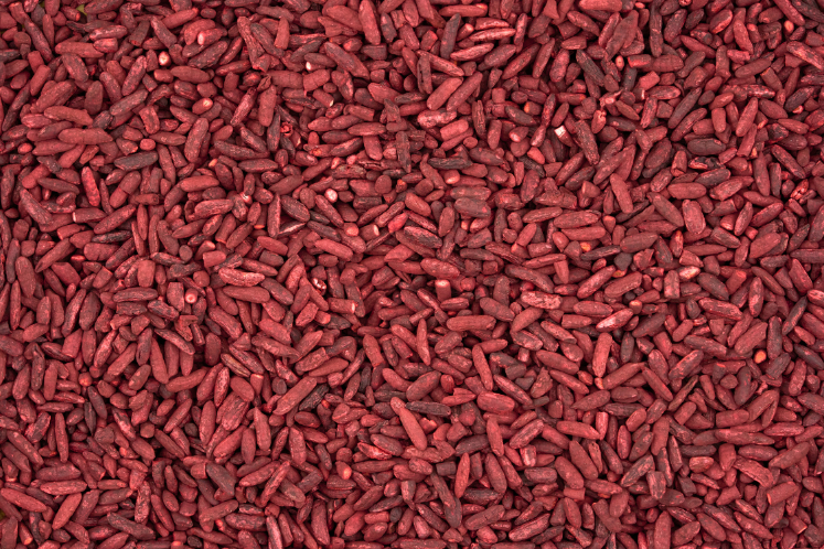 Close-up of dried red yeast rice grains used in supplements