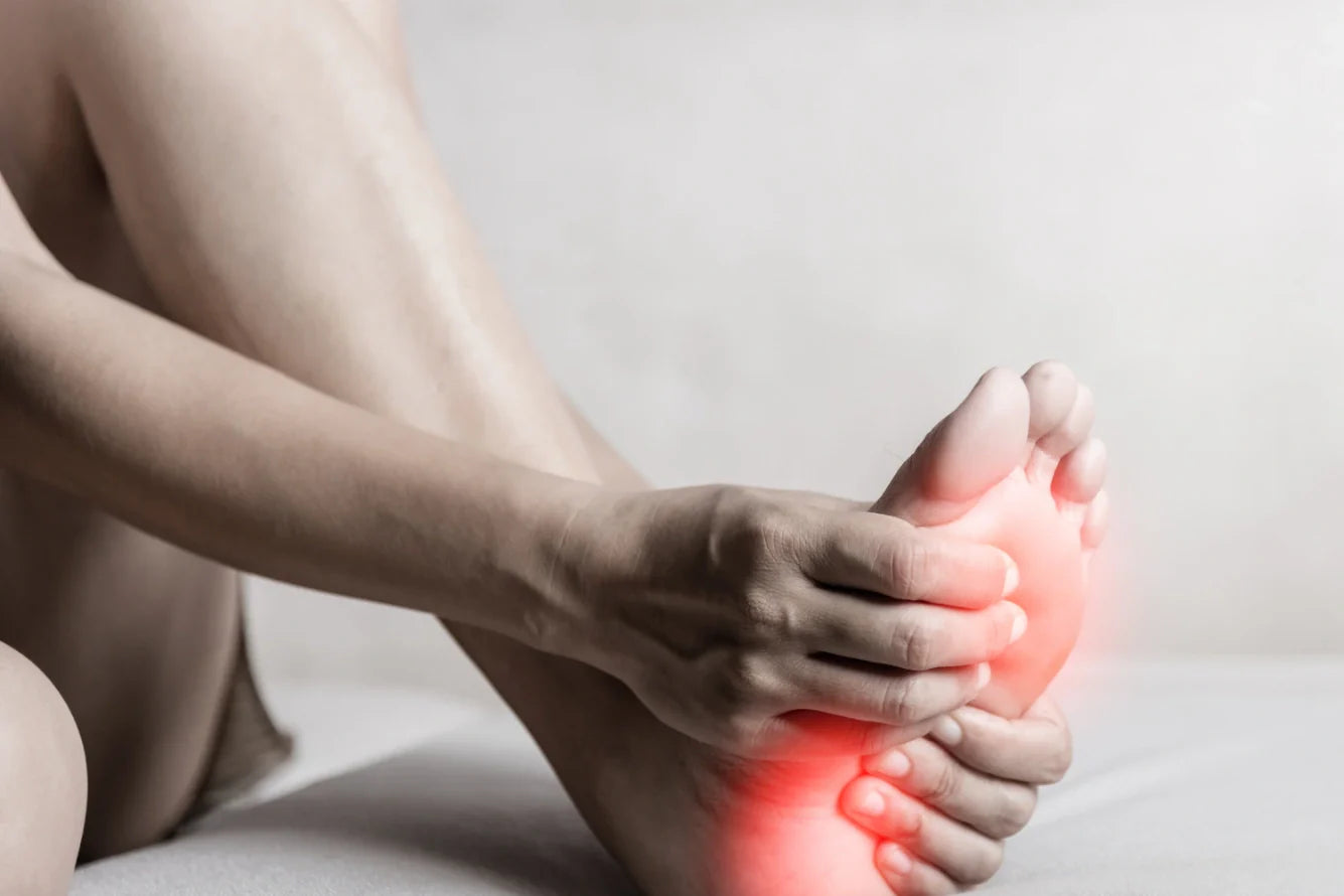 A person holding their swollen heel.