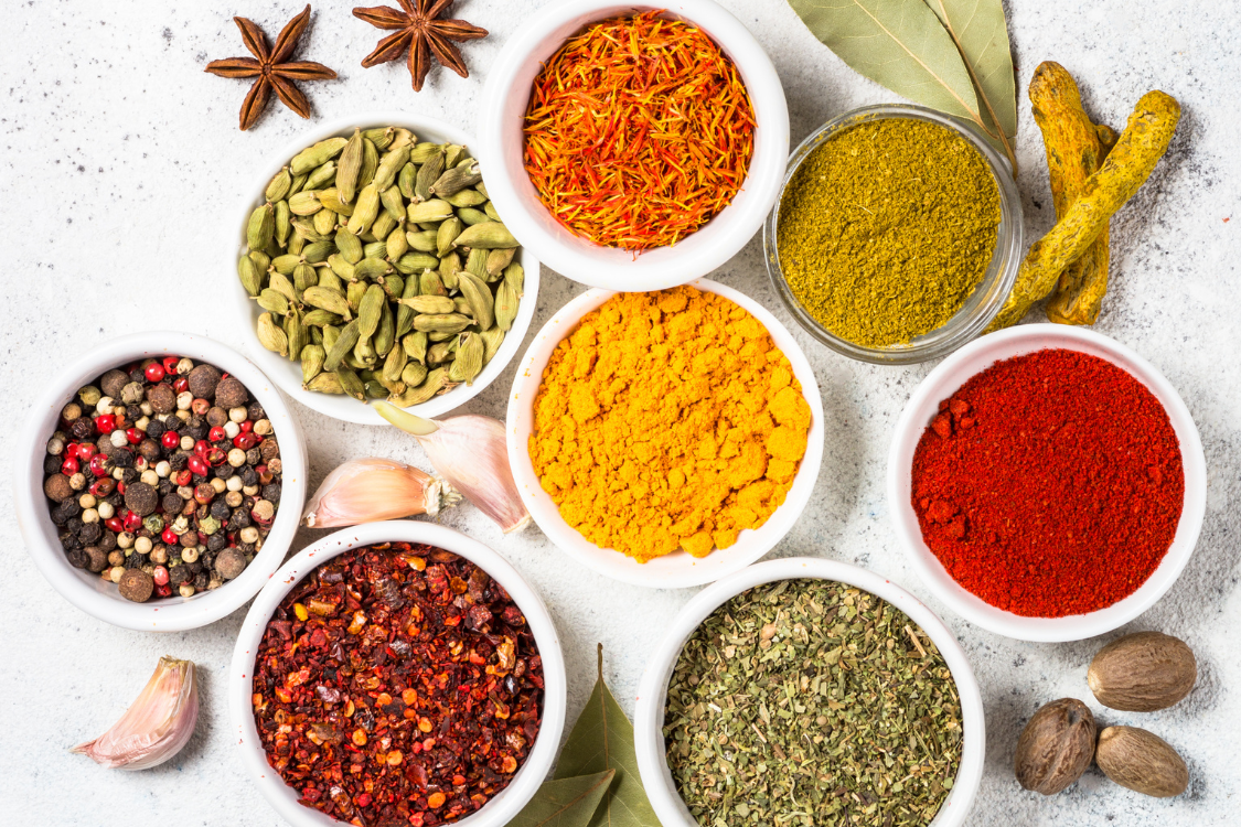 Variety of herbs and spices in bowls often used in natural remedies for prostate support.