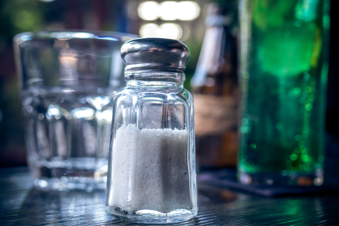 Salt shaker on table showing high sodium linked to kidney stones