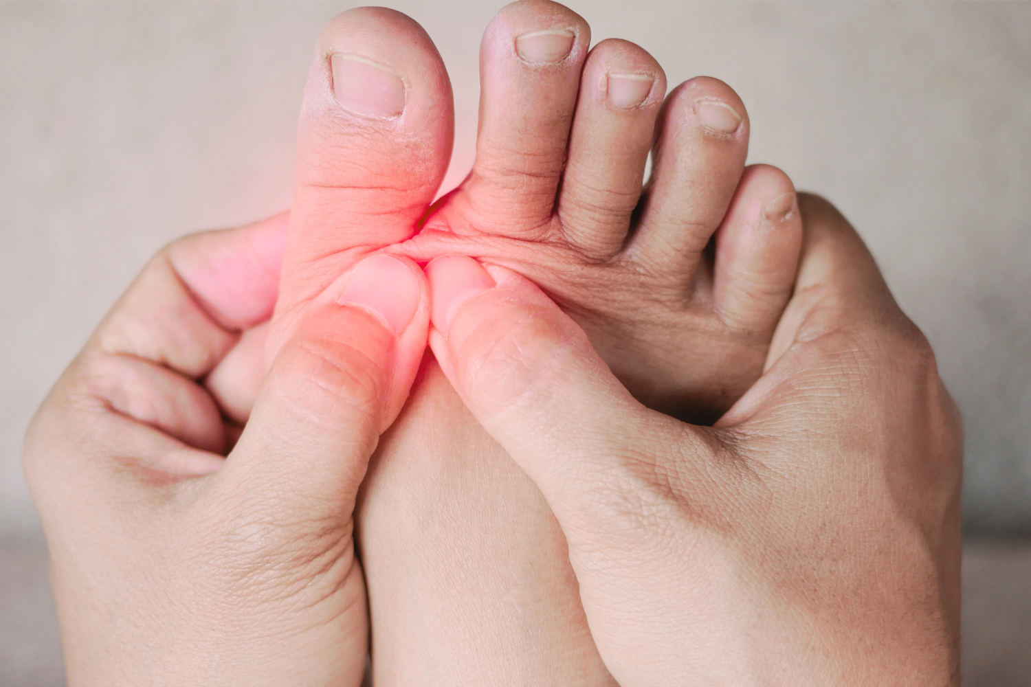 A person holding their foot with a red light on it.