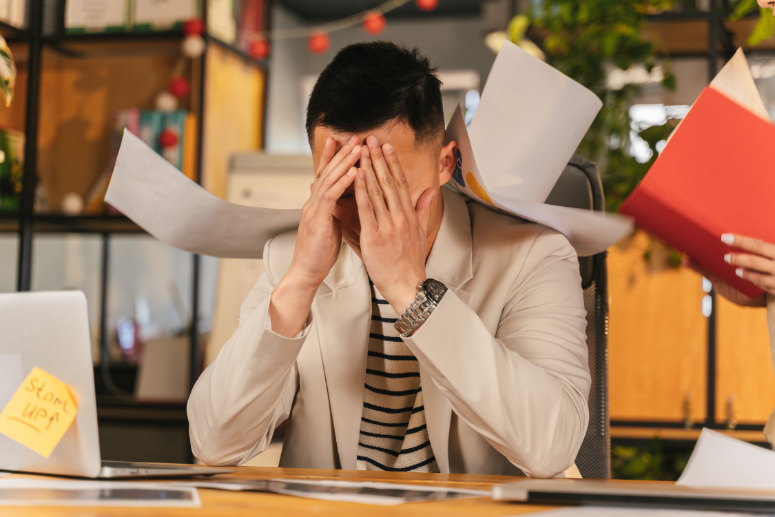  Stressed man overwhelmed at work, showing how emotional stress may worsen gout symptoms